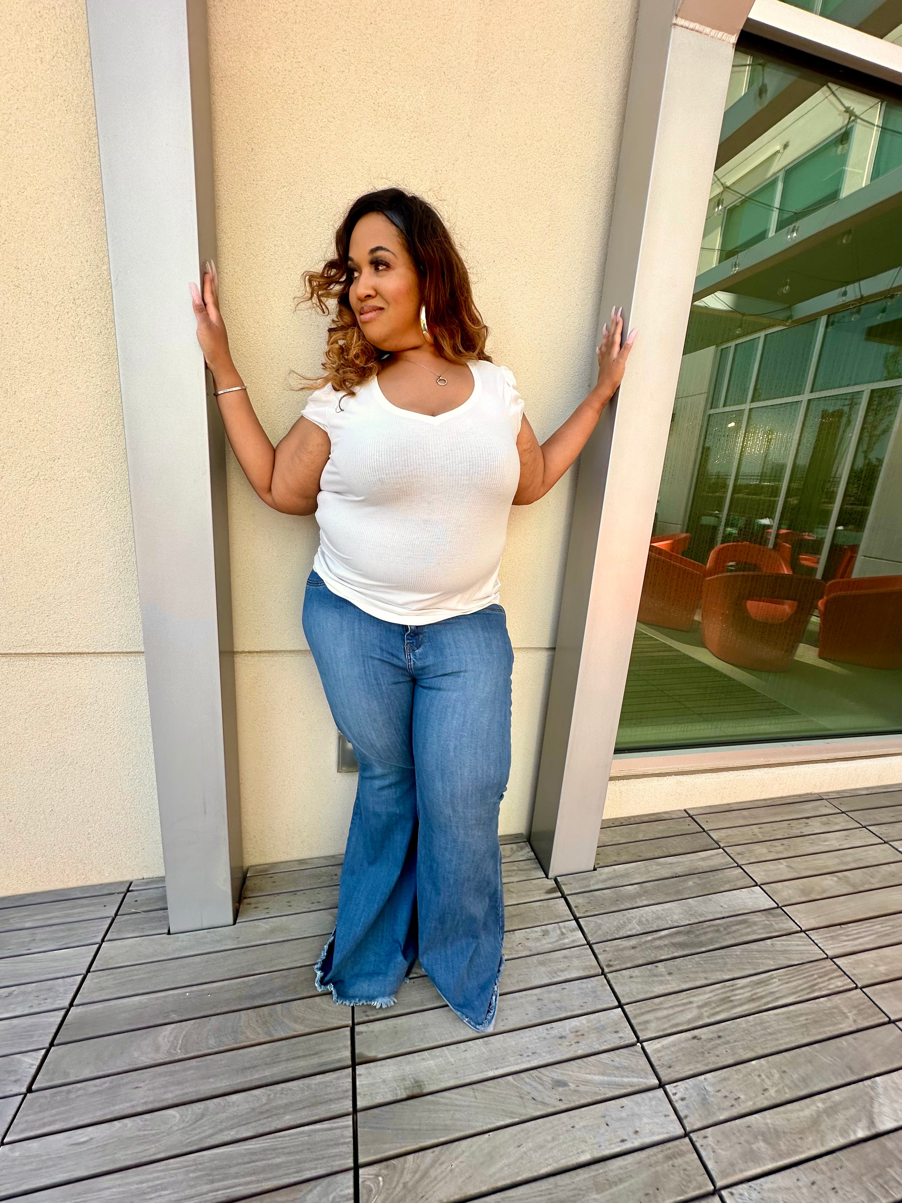Plus-size tall woman wearing best-fitting bell bottom flare jeans in medium blue denim, styled for curves and height-side profile.