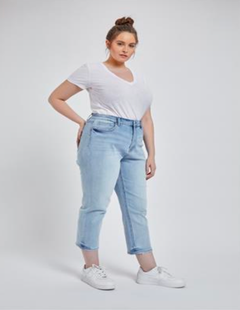 Plus-size model wearing light wash cropped mom jeans with distressed hem, ultra-high rise, and stretch fit for plus-size curves, pocket.