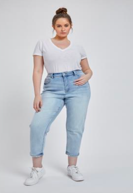 Plus-size model wearing light wash cropped mom jeans with distressed hem, ultra-high rise, and stretch fit for plus-size curves,hip.