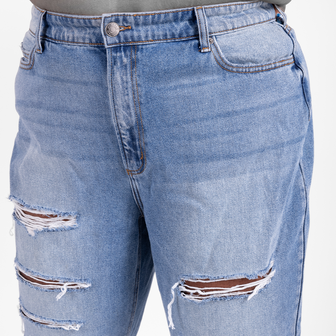 Plus-size woman in Raquel mid-rise rigid boyfriend jeans with front-leg distressed details, styled for a relaxed and structured fit. Close-up waist